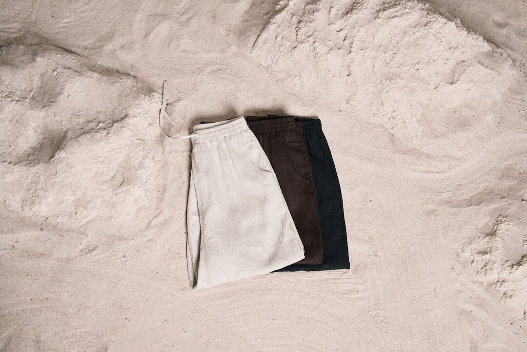Flat lay of linen fabric, oak wood and travertine stone samples